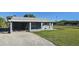 Front exterior view of a single-story home with a covered carport and driveway at 712 Edmund St, Punta Gorda, FL 33950