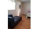 Bright bedroom with a comfy black futon and a twin bed near a window at 806 Hickory Ln, Bradenton, FL 34208