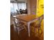 Bright dining area with a light wood table, four chairs, and view into kitchen and sunroom at 806 Hickory Ln, Bradenton, FL 34208
