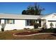 Charming single-story home with manicured lawn and freshly painted white exterior, complete with pleasant landscaping at 806 Hickory Ln, Bradenton, FL 34208