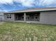 The backyard features a covered patio with several access points to the interior of the home at 9159 Melody Cir, Port Charlotte, FL 33981