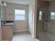 Modern bathroom with granite vanity, tiled shower, and a bright window for natural light at 9159 Melody Cir, Port Charlotte, FL 33981