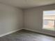 This empty bedroom features a window providing natural light and wood-look tile flooring at 9159 Melody Cir, Port Charlotte, FL 33981