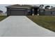 Single-story home featuring a long driveway leading to an attached two-car garage, complemented by a lush lawn at 9159 Melody Cir, Port Charlotte, FL 33981
