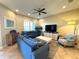 Living room with comfortable blue couches, white coffee table, entertainment center, and large window at 10350 Longshore Rd # 61, Placida, FL 33946