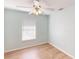 Light blue bedroom with wood-look floors, window coverings, and a ceiling fan at 158 Eppinger Dr, Port Charlotte, FL 33953