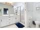 Clean and bright bathroom featuring dual vanities, a glass shower, and white cabinetry at 1796 Scarlett Ave, North Port, FL 34289