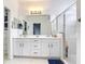 Bright bathroom with double sinks, a walk-in shower, and access to the closet at 1796 Scarlett Ave, North Port, FL 34289