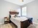 Well-lit bedroom with a wood-framed bed, hardwood floors, and a window at 1796 Scarlett Ave, North Port, FL 34289