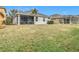 Exterior view of the home from the backyard, showing the screened porch and grassy lawn at 1796 Scarlett Ave, North Port, FL 34289