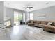 Living room with a brown sectional sofa, ceiling fan, sliding glass doors, and access to the patio at 1796 Scarlett Ave, North Port, FL 34289