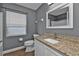 Bathroom with granite countertop, white cabinets, and updated fixtures at 18359 Gypsy Ave, Port Charlotte, FL 33954