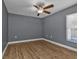 A bedroom featuring wood-look flooring, a ceiling fan, and ample natural light at 18359 Gypsy Ave, Port Charlotte, FL 33954