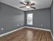 Bedroom with wood-look flooring, ceiling fan, and window overlooking the backyard at 18359 Gypsy Ave, Port Charlotte, FL 33954