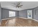Living room with vaulted ceiling, ceiling fan, wood-look flooring, and access to the backyard at 18359 Gypsy Ave, Port Charlotte, FL 33954