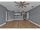 Spacious living room with wood-look flooring and ceiling fan, open to the kitchen at 18359 Gypsy Ave, Port Charlotte, FL 33954