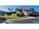 Building exterior with American flag, pond, and tropical landscaping at 197 Tropicana Dr # 1512, Punta Gorda, FL 33950