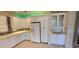 White kitchen with tile floor, glass-front cabinets, and stainless steel appliances at 197 Tropicana Dr # 1512, Punta Gorda, FL 33950