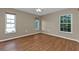 Bedroom with wood flooring and two windows at 23309 Hartley Ave, Port Charlotte, FL 33954