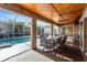 Covered outdoor lanai featuring a wood ceiling, dining area, ceiling fan and a view of the pool at 23309 Hartley Ave, Port Charlotte, FL 33954