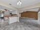 Open living area with breakfast bar and kitchen view; features neutral colors and tile flooring at 23309 Hartley Ave, Port Charlotte, FL 33954