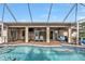 Inviting pool area with covered patio, outdoor seating, and a heater at 23309 Hartley Ave, Port Charlotte, FL 33954