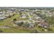 Aerial view of a residential area featuring houses, roads, trees, and green spaces at 26090 Huanuco Dr, Punta Gorda, FL 33983