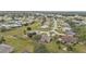 Aerial view of a residential area with houses, roads, trees, and green spaces at 26090 Huanuco Dr, Punta Gorda, FL 33983