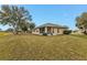 Exterior view of a house with a screened porch and a large, grassy backyard at 26090 Huanuco Dr, Punta Gorda, FL 33983