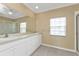 Bathroom with double vanity, large mirror, tiled floor and window with blinds at 26090 Huanuco Dr, Punta Gorda, FL 33983