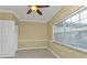 Empty bedroom with tiled floor, ceiling fan, and large window with blinds at 26090 Huanuco Dr, Punta Gorda, FL 33983
