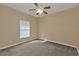 Empty bedroom with ceiling fan, window with blinds, and carpeted flooring at 26090 Huanuco Dr, Punta Gorda, FL 33983