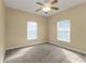 Spacious, carpeted bedroom with two large windows and ceiling fan at 26090 Huanuco Dr, Punta Gorda, FL 33983