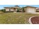One-story home with a large front lawn, landscaping, and an attached garage at 26090 Huanuco Dr, Punta Gorda, FL 33983