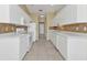 Galley kitchen featuring white cabinets and tile backsplash at 26090 Huanuco Dr, Punta Gorda, FL 33983