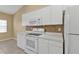 Kitchen with white appliances, countertops and wood-look tile at 26090 Huanuco Dr, Punta Gorda, FL 33983