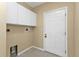 Laundry room with white cabinets, door, and tiled floor at 26090 Huanuco Dr, Punta Gorda, FL 33983