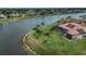 An aerial view of the home's backyard, screened-in pool, and nearby lake at 26387 Madagascar Rd, Punta Gorda, FL 33983