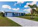 Newly built home with a metal roof, light blue exterior, and a long driveway at 2877 Howe Rd, Port Charlotte, FL 33981