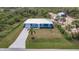 Aerial view of a charming one-story home with a well-manicured lawn and a concrete driveway at 2877 Howe Rd, Port Charlotte, FL 33981