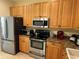 Kitchen with stainless steel appliances, wood cabinets, and granite countertops at 3100 Sheboygan Ave, North Port, FL 34286