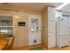 Kitchen entry with white cabinets, wood flooring, and pet door at 368 Catamaran Ct, North Port, FL 34287
