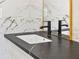 Modern bathroom detail highlighting a black faucet and dark countertop with a gold trim mirror at 4301 Marcella Ter, North Port, FL 34286