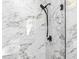 Close-up of a shower with black fixtures against a marble tiled wall at 4301 Marcella Ter, North Port, FL 34286