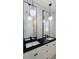 Modern bathroom with a black countertop, dual vanities, and marble tile at 4301 Marcella Ter, North Port, FL 34286