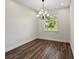 Dining room with a modern chandelier, dark wood-look flooring, and large window at 4301 Marcella Ter, North Port, FL 34286