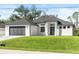 Modern home with a black garage door, impact windows, and a well-manicured lawn showcasing curb appeal at 4301 Marcella Ter, North Port, FL 34286