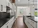 Modern white kitchen with dark countertops, an island, and an adjacent dining area at 4301 Marcella Ter, North Port, FL 34286