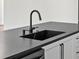 Modern kitchen with dark countertops, a black sink, and white cabinets at 4301 Marcella Ter, North Port, FL 34286