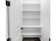 Empty white pantry with built-in shelves and dark wood-look flooring at 4301 Marcella Ter, North Port, FL 34286